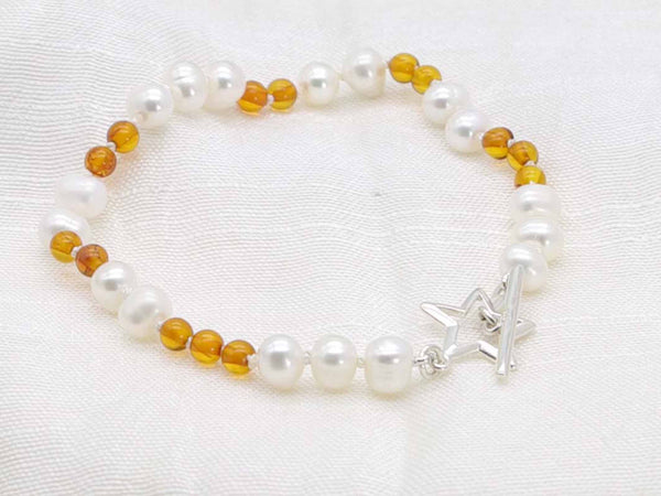White pearl and cognac amber hand knotted bracelet with star toggle from Jewellery by Linda