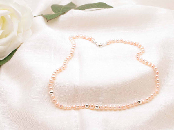 Single strand of elegant pale peach hand knotted pearls featuring polished silver spheres from Jewellery by Linda, oozing vintage glamour