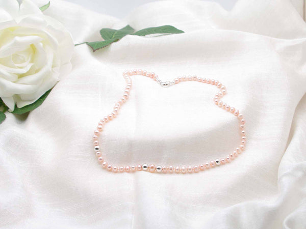 Single strand of elegant pale peach hand knotted pearls featuring polished silver spheres from Jewellery by Linda. Sophisticated vintage glamour