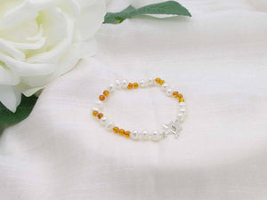 White pearl and cognac amber hand knotted bracelet with sterling silver star toggle from Jewellery by Linda