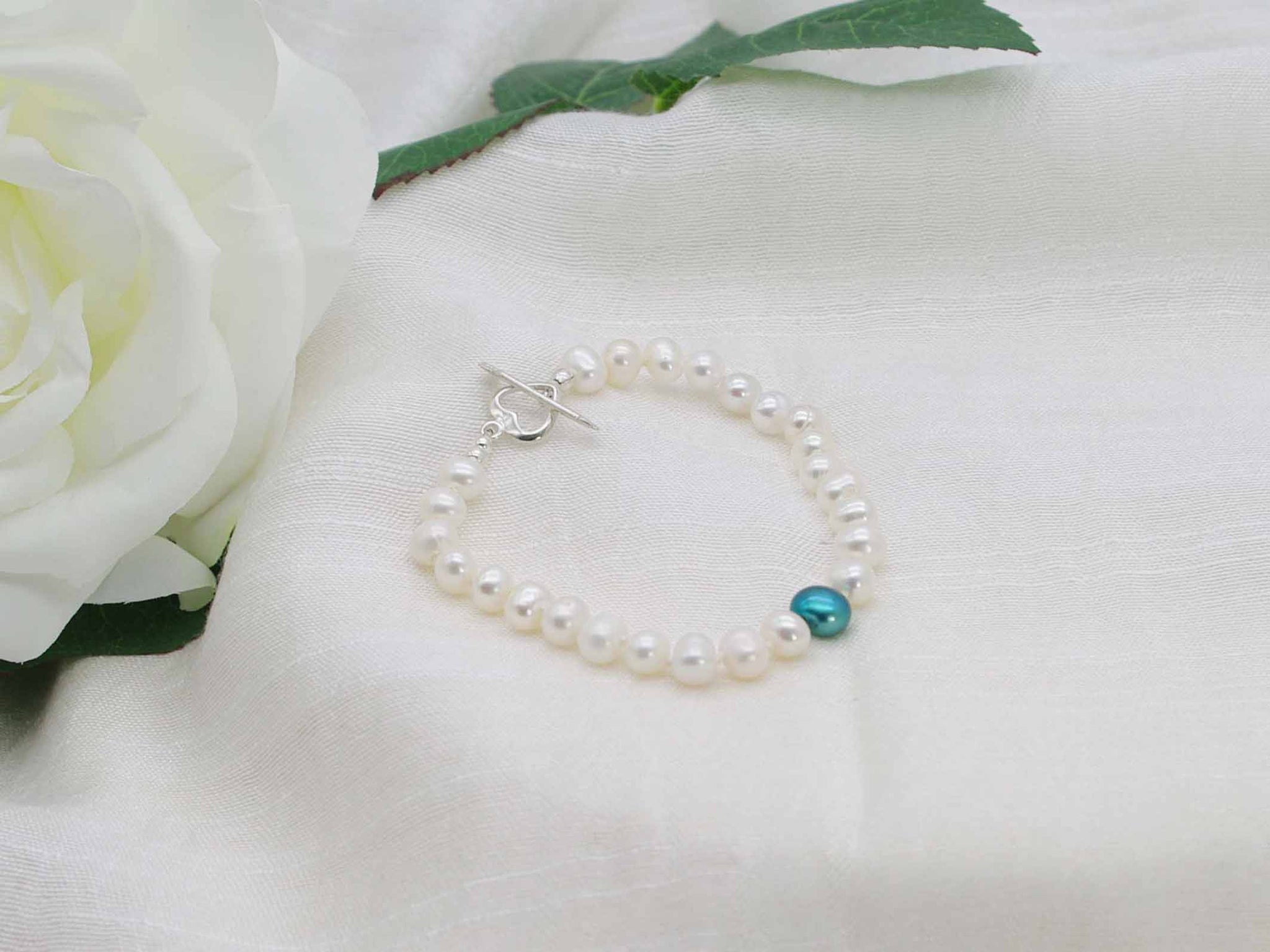 Love Teal white pearl hand knotted bracelet with feature teal pearl and sterling silver heart toggle clasp from Jewellery by Linda