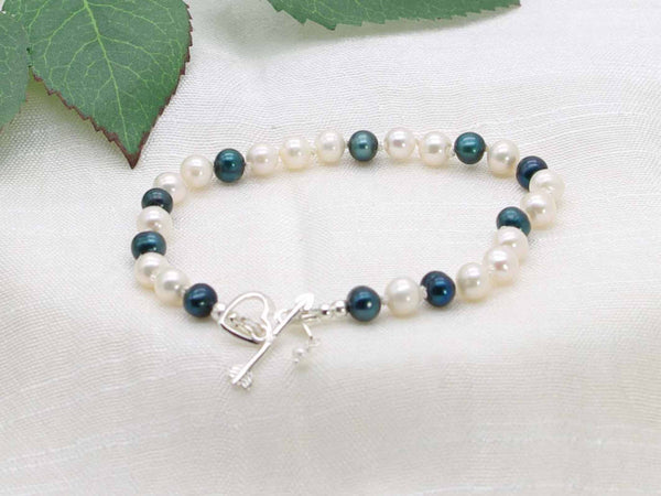 Ever Green hand knotted white and dark green pearl bracelet featuring a silver  heart and arrow toggle clasp from Jewellery by Linda