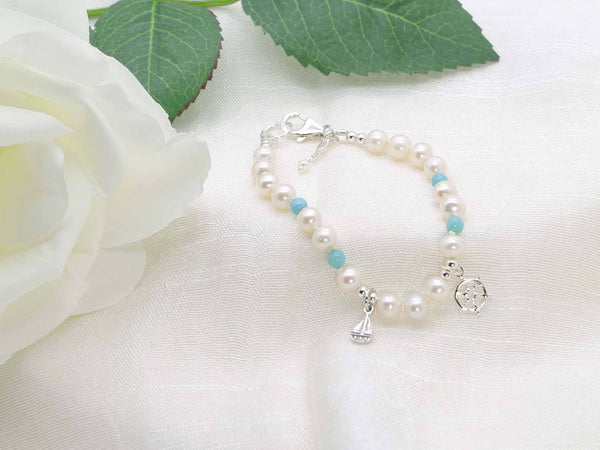 Cute Maritime bracelet with hand knotted ivory pearls and larimar. Featuring sterling silver boat and ships wheel charms. From Jewellery by Linda