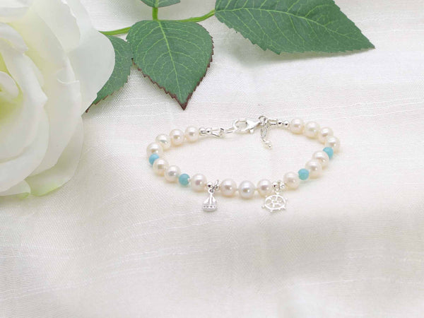 Cute Maritime bracelet with hand knotted ivory pearls and larimar. Featuring sterling silver maritime charms of a boat and ships wheel. From Jewellery by Linda