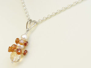 Diana necklace. Hessonite garnets, with a white freshwater cultured pearl and citrine. Suspended from a polished sterling silver handmade heart on a sterling silver chain. Jewellery by Linda Sweet Heart Collection. 46cm chain. 3.5cm pendant