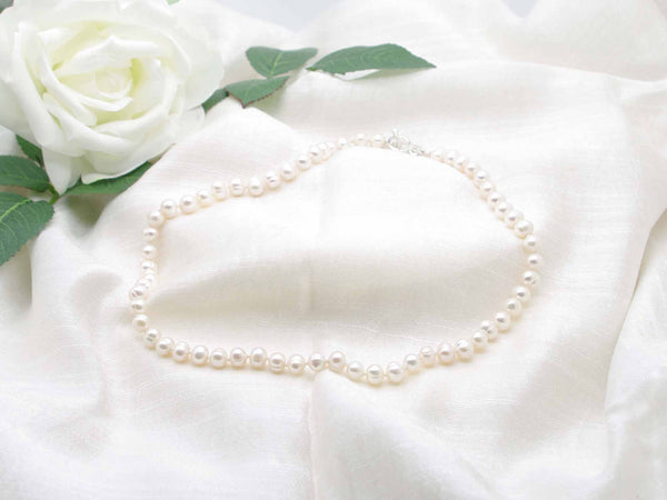 Regal white cultured pearl knotted necklace with crown toggle clasp