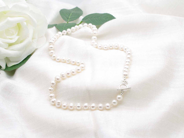 Sophisticated white cultured pearl knotted necklace with sterling silver crown toggle clasp