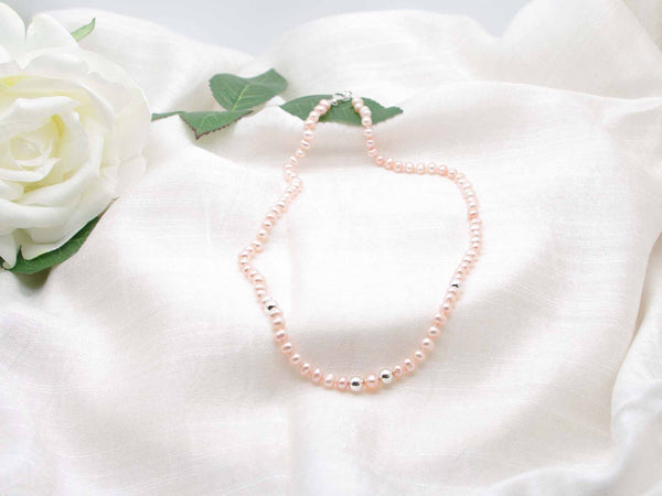 Single strand of elegant pale peach hand knotted pearls featuring polished silver spheres from Jewellery by Linda
