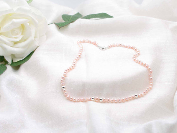 Graceful single strand of elegant pale peach hand knotted pearls featuring polished silver spheres from Jewellery by Linda