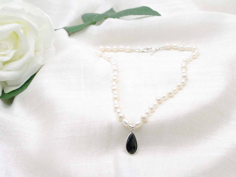 Hand knotted ivory culture pearl necklace with striking feature black spinel faceted drop.  Elegant monochrome sophistication.