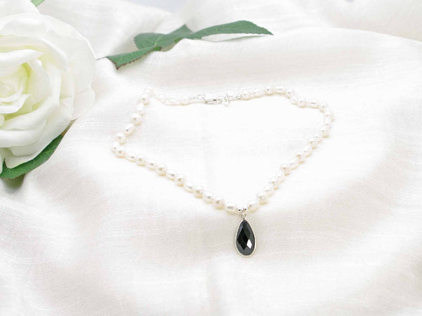 Hand knotted ivory culture pearl necklace with striking feature black spinel faceted drop from Jewellery by Linda.  Classic monochrome sophistication.