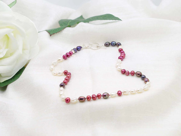Very Berry hand knotted single strand of pearls in berry colours. Distinctive contemporary glamour from Jewellery by Linda. Finished with a rope design toggle clasp in sterling silver