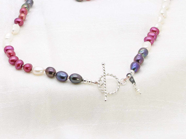 Very Berry hand knotted single strand of pearls in berry colours. Distinctive contemporary glamour from Jewellery by Linda. Featuring a rope design sterling silver toggle clasp