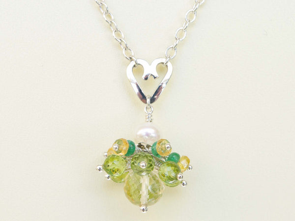 Persephone necklace. Emeralds, yellow sapphires and peridots with a white freshwater cultured pearl and citrine. Suspended from a polished sterling silver handmade heart on a sterling silver chain. Unique. 46cm chain. 3cm pendant