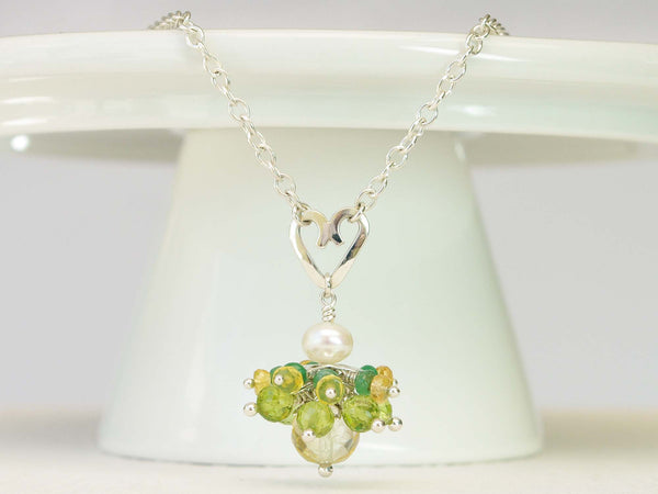 Persephone necklace. Emeralds, yellow sapphires and peridots with a white freshwater cultured pearl and citrine. Suspended from a polished sterling silver handmade heart on a sterling silver chain. Sweet Heart Collection. 46cm chain. 3cm pendant